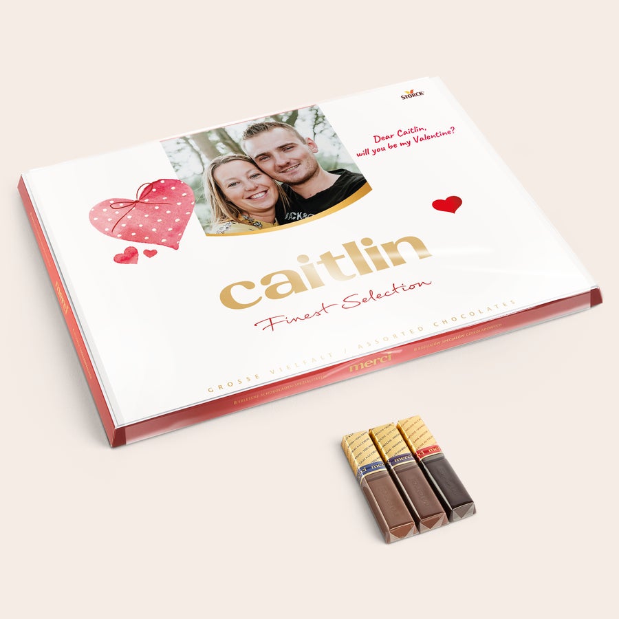 Personlig Merci-sjokolade i gaveeske med gratulasjonskort Merci sjokoladeeske med et personlig kort trykket med et bilde og teksten "caitlin".