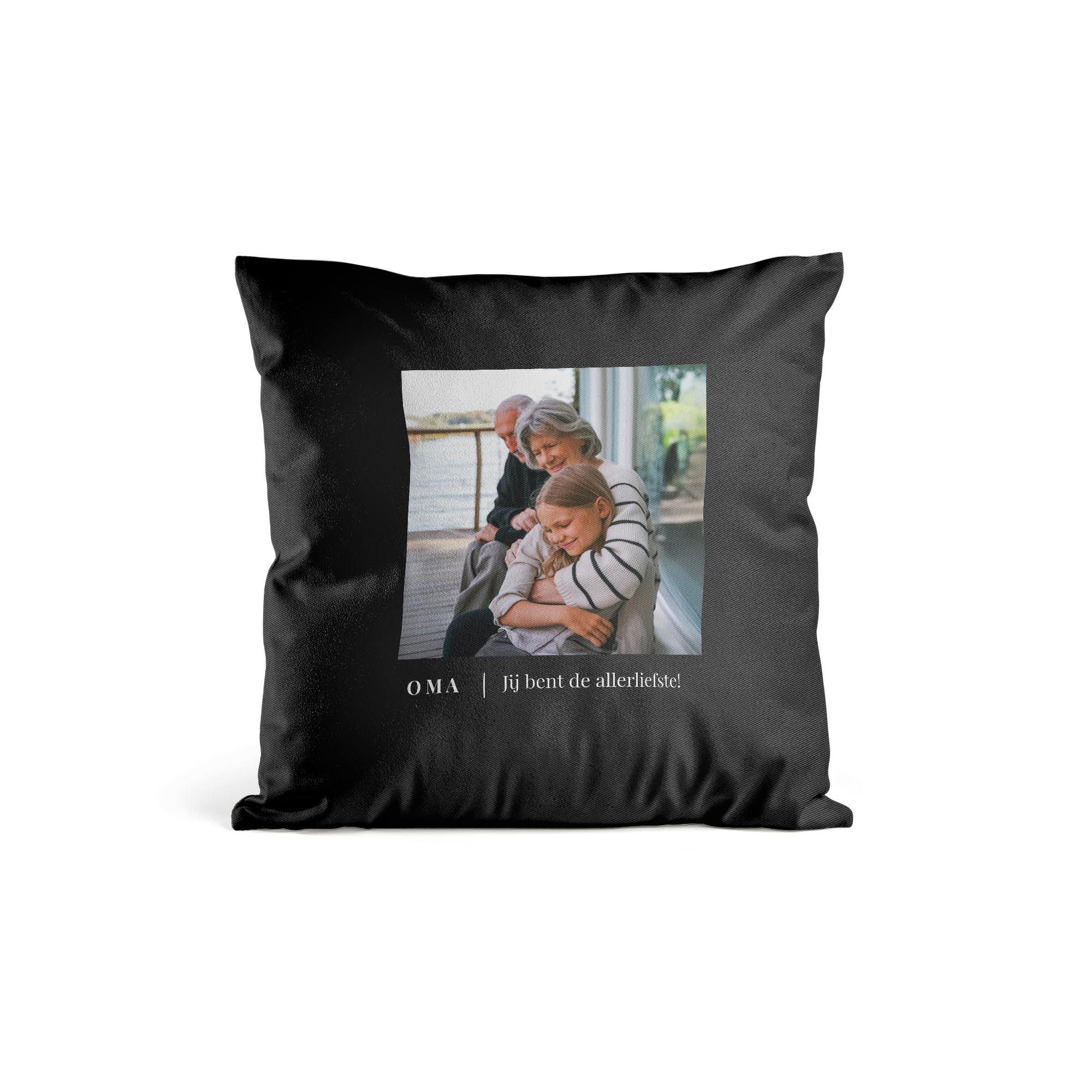 Zwart gepersonaliseerd kussen bedrukt met een foto van een meisje die een oudere vrouw omhelst en de tekst Oma Jij bent de allerliefste!