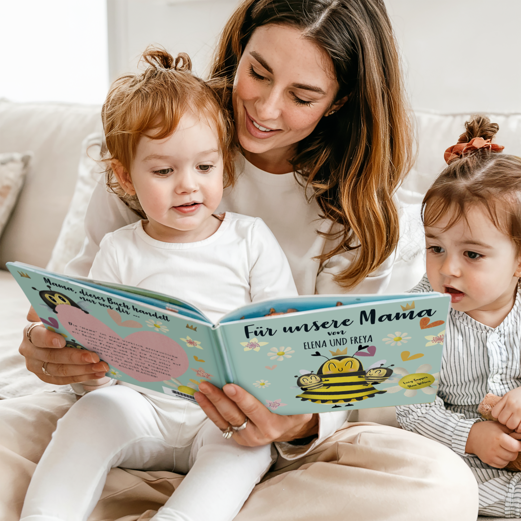 Mutter liest personalisiertes Buch &quot;Für unsere Mama von ELENA UND FREYA&quot; mit ihren zwei Kindern, ein lustiges Buch für Mama.