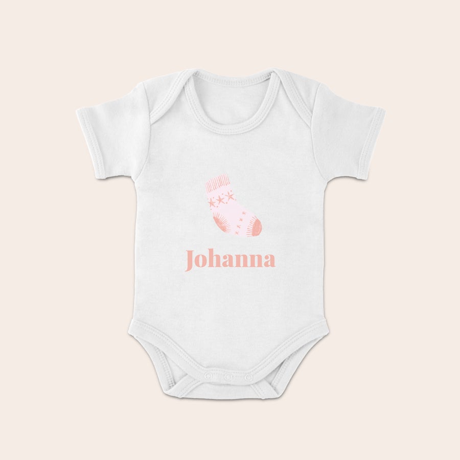 Weihnachtsbody Baby Weißer Baby Body mit rosa Weihnachtssocken-Design und personalisiertem Namen Johanna bedruckt.