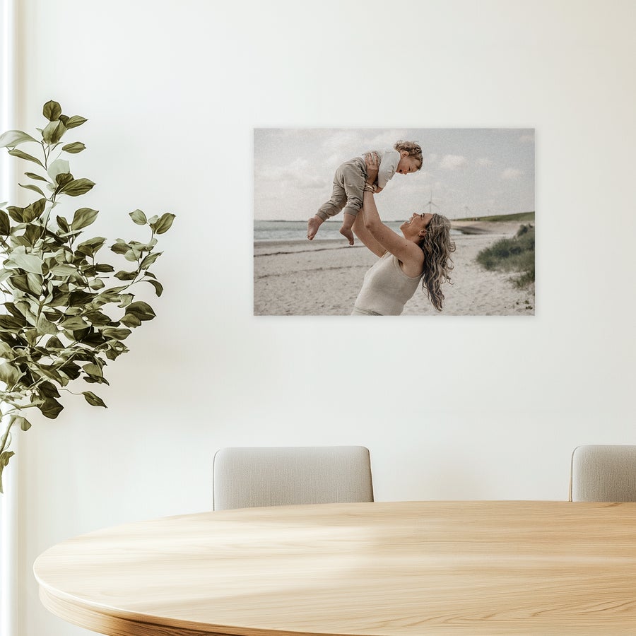 Foto på forex Tilpasset foto på forex med motiv af en kvinde der løfter et barn i luften på stranden, en vidunderlig dekoration.