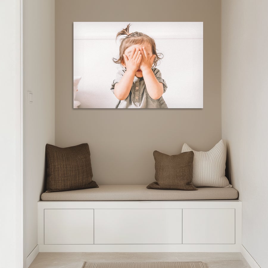Foto auf Alu Fototafel mit eigenem Foto eines spielenden Kindes, die an einer Wand hängt.