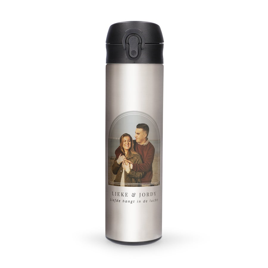 Thermos bedrukken Zilveren luxe waterfles met naam en foto van een stel, bedrukt met de tekst Lieke & Jordy, Liefde hangt in de lucht