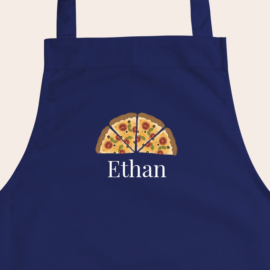 Barnförkläde Mörkblått personligt förkläde för barn, tryckt med en pizzadesign och namnet Ethan. Även den yngsta kocken behöver ett personligt förkläde.