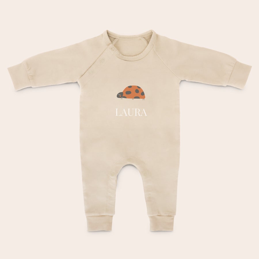 Babystrampler bedrucken Beiger personalisierter Babystrampler mit Marienkäfer-Druck und dem Namen LAURA, ein süßes Geschenk zur Geburt.