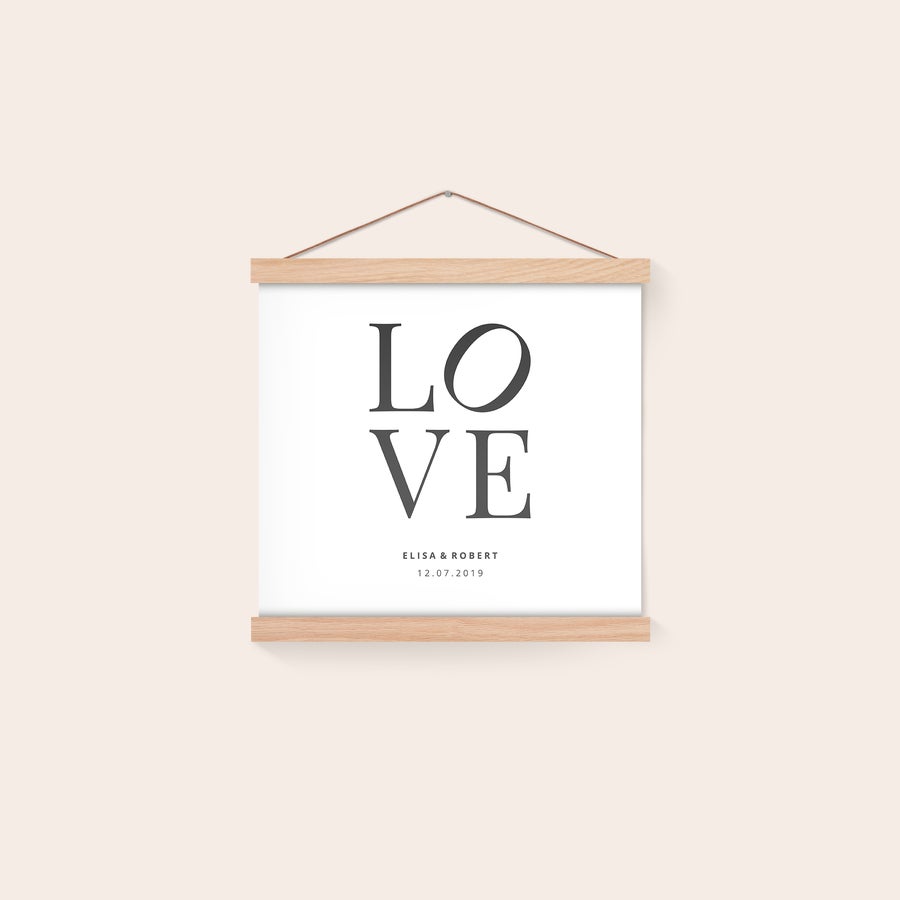 Poster personaliseren met posterhanger Gepersonaliseerde poster met magnetische posterhanger, bedrukt met de tekst 'LOVE', en namen 'Elisa & Robert' en datum '12.07.2019'.