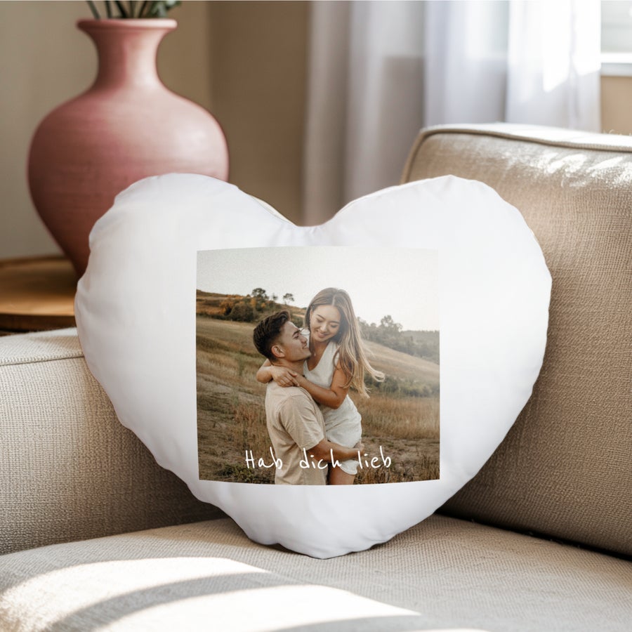 Herzkissen mit Foto Ein weißes, bedrucktes herzförmiges Kissen mit einem Foto eines Pärchens und dem Text Hab dich lieb, ideal für schlechte Träume.