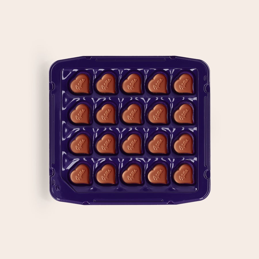 Pralinés de Milka Amor Caixa personalizada Milka com bombons de chocolate em formato de coração e recheio de creme de avelã.
