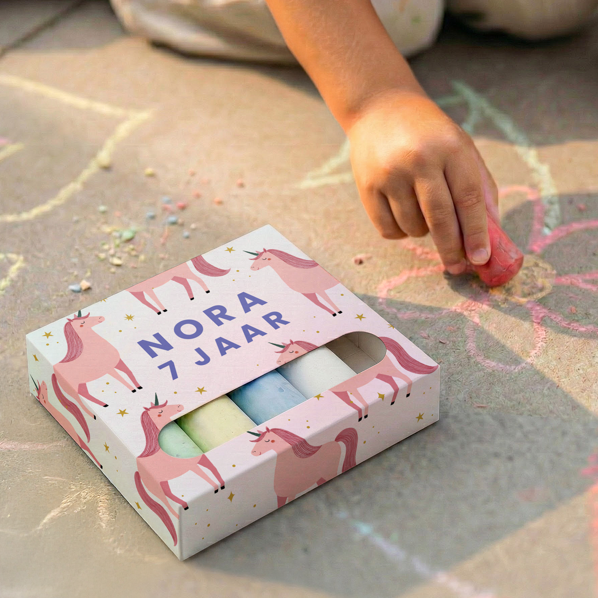 Een doosje stoepkrijt met eenhoorns, gepersonaliseerd met de naam Nora 7 jaar, perfect als verjaardagscadeau.