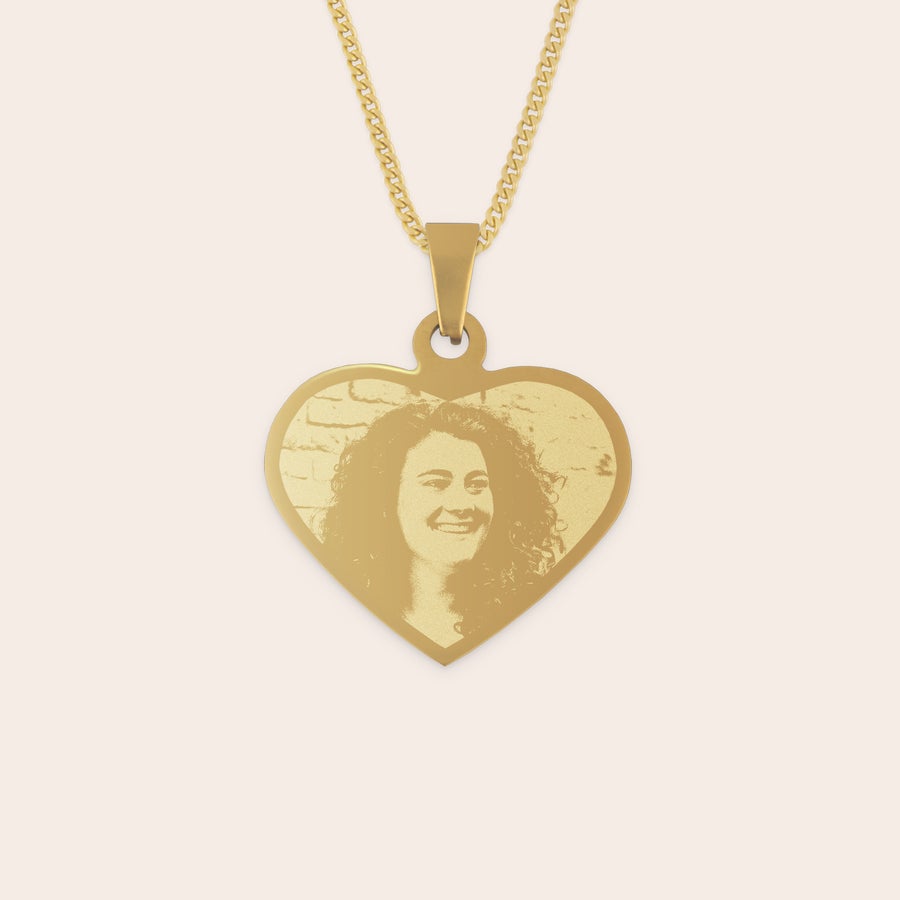 Collier cœur gravé Pendentif cœur doré gravé avec une photo personnalisée d'une femme souriante, suspendu à une chaîne dorée.