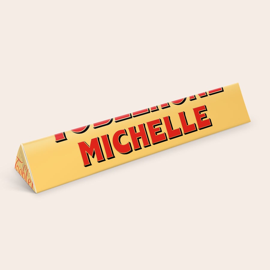 Toblerone mit Namen Personalisierte Toblerone Größe S mit dem Namen Michelle in Rot auf goldener Verpackung gedruckt.