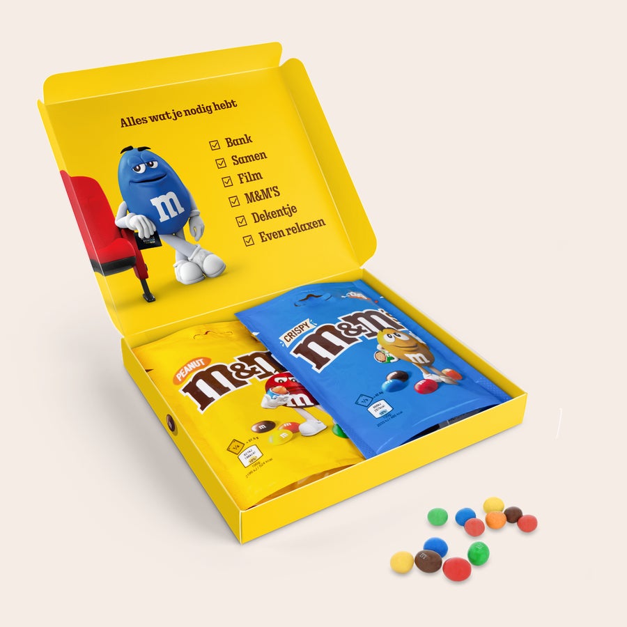 Gepersonaliseerde M&M's moviebox Een geopende M&M'S Film Giftbox met twee gepersonaliseerde zakken M&M'S Peanut en M&M'S Crispy, om hun filmavond iets bijzonders te maken.