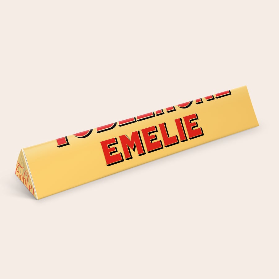 Toblerone med namn En personlig Toblerone med namn och bild på förpackningen, med texten EMELIE i rött.