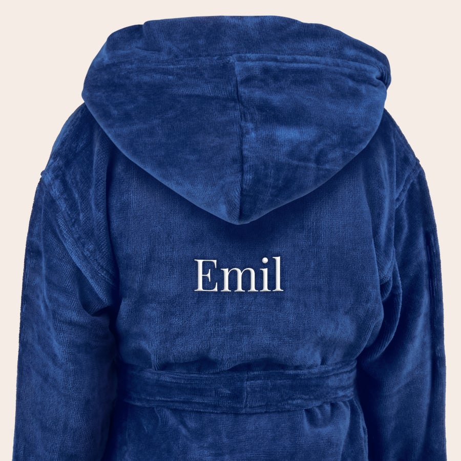 Badrock - barn Mjuk personlig badkappa för barn i mörkblått med luva, broderad med namnet "Emil" i vitt på ryggen.