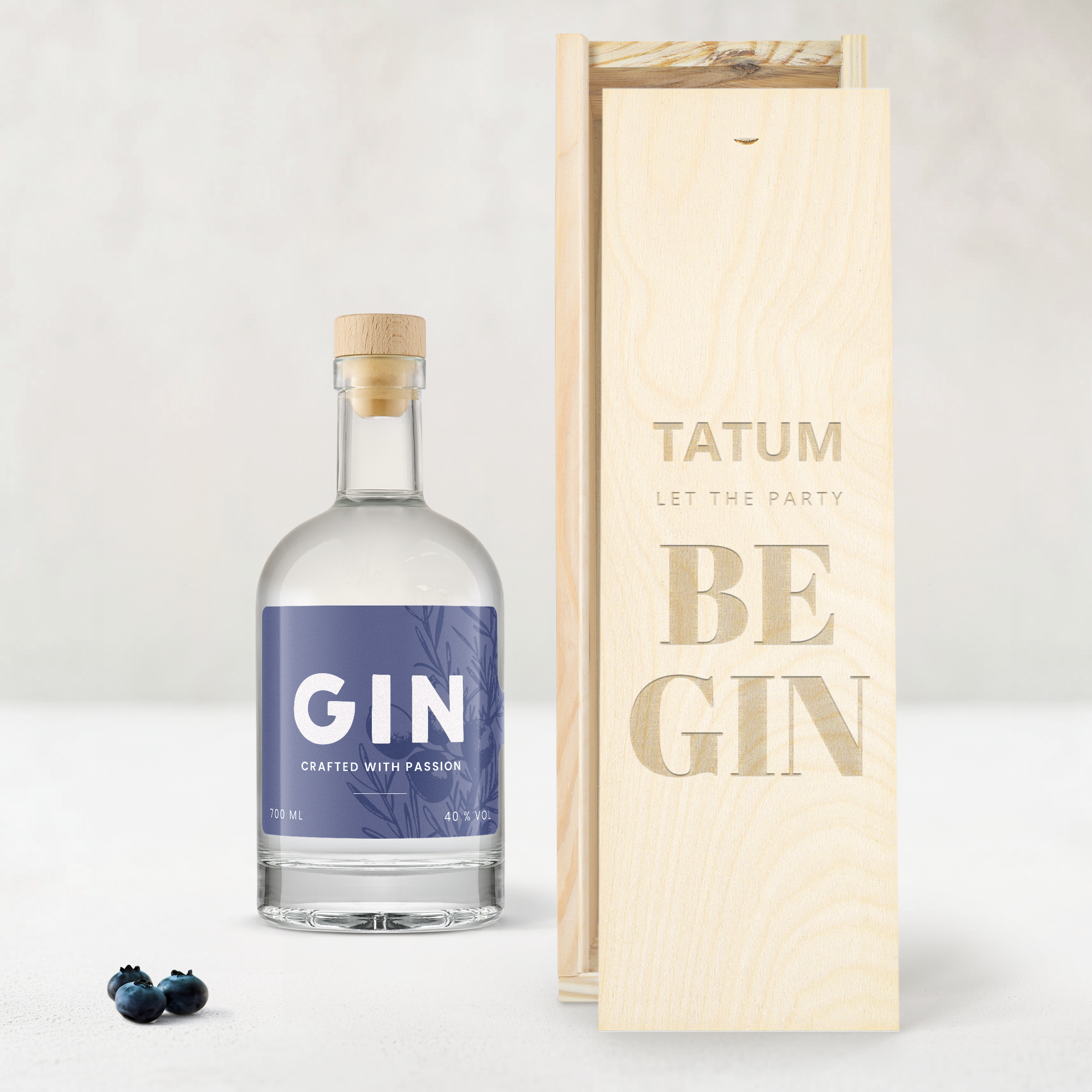 Fles gin met paars etiket en gegraveerde houten kist met de naam Tatum en tekst Let the Party Be Gin