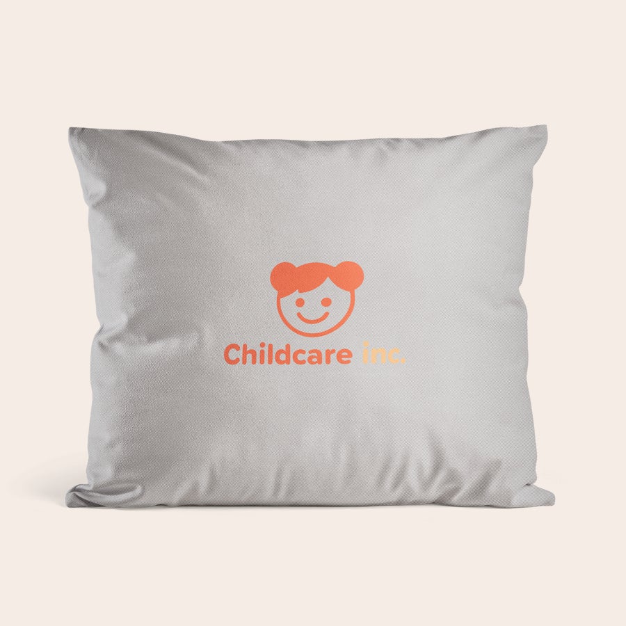 Cojin personalizado con foto Almohada personalizada gris con logotipo impreso de "Childcare Inc." y un icono de cara sonriente, para sorprender con tu propia foto y texto.