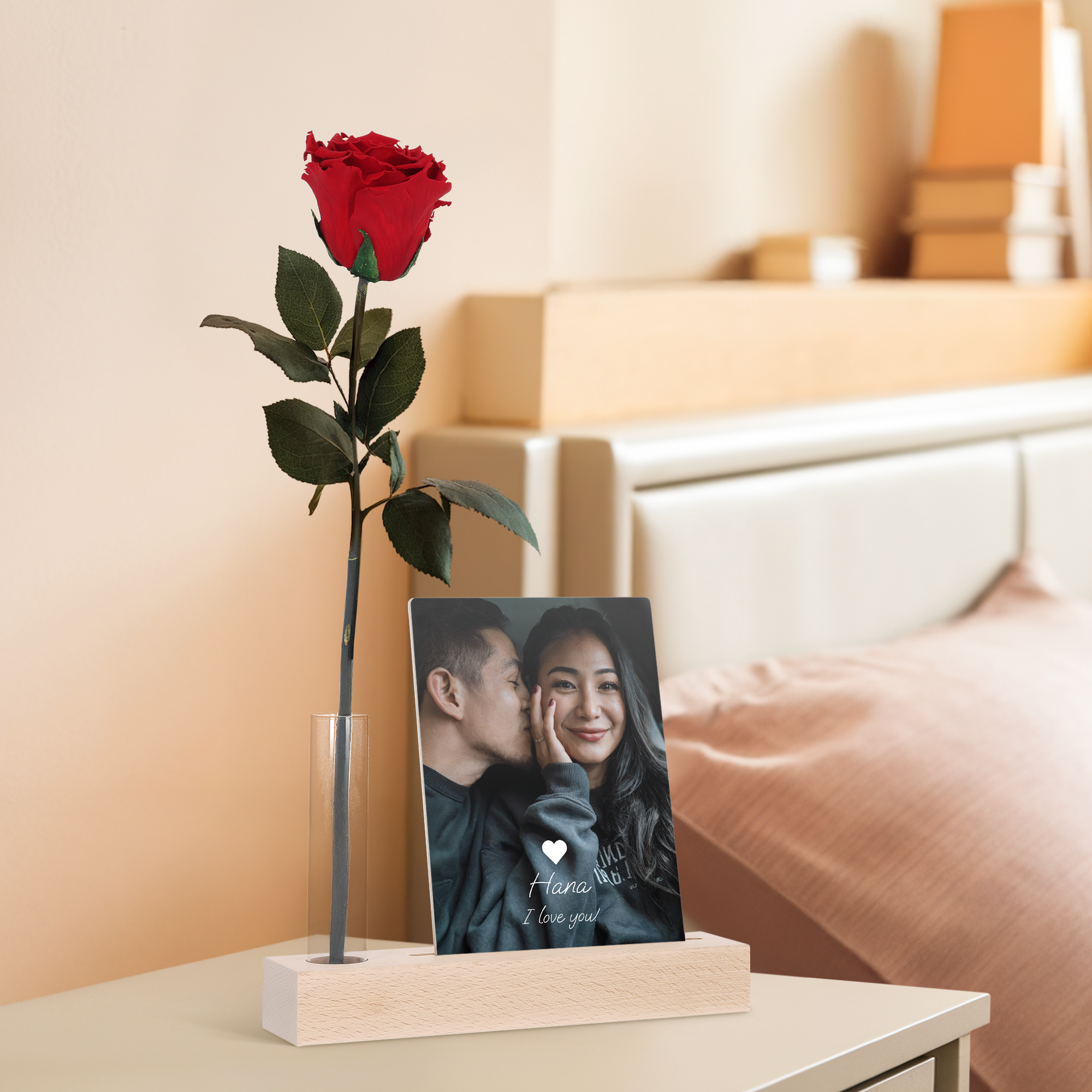 Infinity Rose valokuvatelineellä, jossa punainen ruusu lasiputkessa ja puinen valokuvakortti pariskunnan kuvalla ja tekstillä "Hana I love you!"